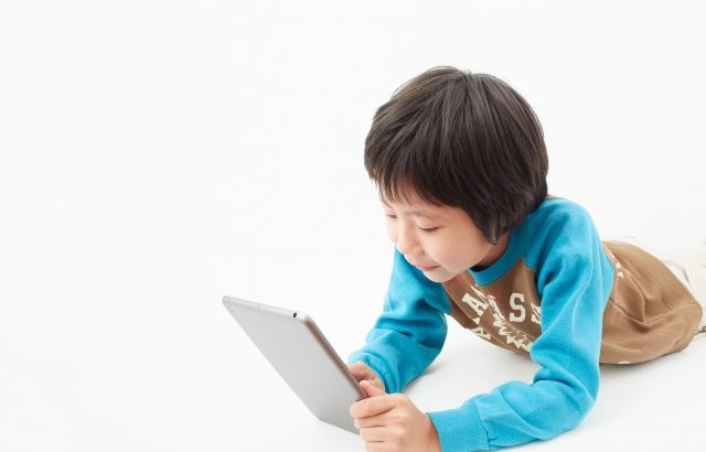 タブレットを見る子供